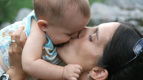 mother kissing baby