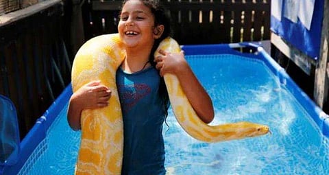 11 അടി നീളമുള്ള പെരുമ്പാമ്പിനൊപ്പം നീന്തിത്തുടിച്ച് എട്ടുവയസ്സുകാരി ( വീഡിയോ)