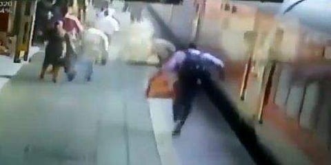 കാല്‍ തെറ്റി സ്ത്രീ ഓടുന്ന ട്രെയിനിന് അടിയിലേക്ക്; രക്ഷകനായി പൊലീസുകാരന്‍ ( വീഡിയോ)
