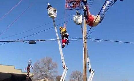 വൈദ്യുതിലൈനില്‍ കുടുങ്ങിയ സാന്താക്ലോസിനെ രക്ഷിക്കുന്നു/ ട്വിറ്റര്‍ ചിത്രം