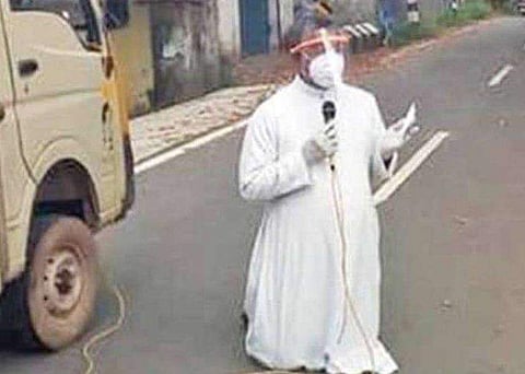 'കൂട്ടം കൂടരുത്, ദയവായി വീട്ടിലിരിക്കൂ'- നടു റോഡിൽ മുട്ടുകുത്തി വൈദികന്റെ അപേക്ഷ