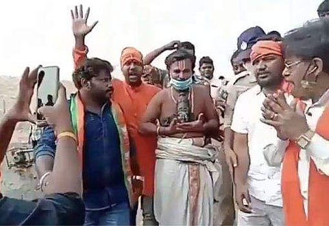 ക്ഷേത്ര കുളത്തിൽ കണ്ടെത്തിയ വി​ഗ്രഹത്തിന്റെ തലയുമായി പൂജാരി/ വിഡിയോ സ്ക്രീൻഷോട്ട്