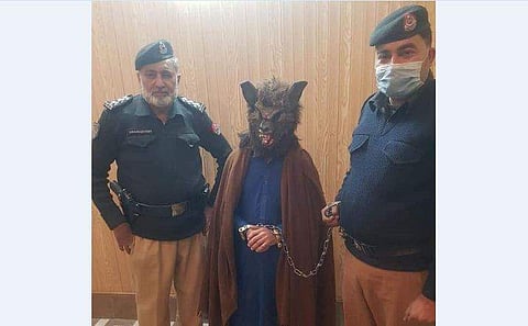 ചെന്നായയുടെ മുഖംമൂടിയണിഞ്ഞതിന് അറസ്റ്റിലായ യുവാവ് പൊലീസുകാർക്കൊപ്പം/ ട്വിറ്റർ