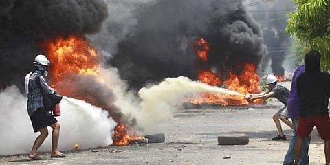 തീ അണയ്ക്കുന്ന പ്രതിഷേധക്കാര്‍/ എപി ചിത്രം