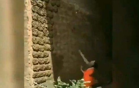 മതിലില്‍ ചാണകവറളി എറിഞ്ഞ് പതിപ്പിക്കുന്ന സ്ത്രീ