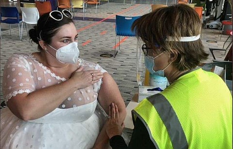 വിവാഹവസ്ത്രത്തില്‍ കോവിഡ് വാക്‌സിന്‍ സ്വീകരിക്കാന്‍ എത്തിയ യുവതി /ചിത്രം ട്വിറ്റര്‍