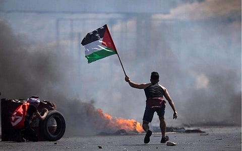 വെസ്റ്റ് ബാങ്കില്‍ ഇസ്രയേലി സൈന്യത്തിനെതിരായ പ്രതിഷേധത്തിനിടെ പലസ്തീനി പകാത ഉയര്‍ത്തിക്കാട്ടുന്ന പ്രക്ഷോഭകന്‍/എപി