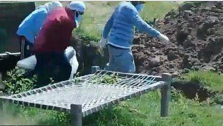 ജെസിബിയില്‍ കൊണ്ടുവന്ന മൃതദേഹം മറവുചെയ്യാന്‍ എടുക്കുന്ന മക്കള്‍