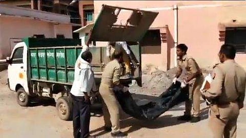 കോവിഡ് രോഗിയുടെ മൃതദേഹം മാലിന്യവണ്ടിയിലേക്ക് വലിച്ചെറിയുന്നു