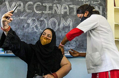 കോവിഡ് വാക്‌സിനേഷനിടെ സെല്‍ഫി എടുക്കുന്ന യുവതി