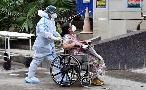 കോവിഡ് രോഗിയെ ആശുപത്രിയില്‍  എത്തിക്കാന്‍ സഹായിക്കുന്ന ആരോഗ്യപ്രവര്‍ത്തകന്‍: പിടിഐ, ഫയല്‍ ചിത്രം