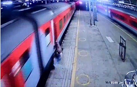 ഓടുന്ന ട്രെയിനില്‍ ചാടിക്കയറുന്നതിനിടെ രക്ഷപ്പെടുന്ന യുവാവ്‌