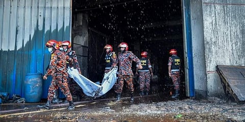 തീപിടിത്തതില്‍ മരിച്ചയാളുടെ മൃതദേഹം പുറത്തേയ്ക്ക് കൊണ്ടുവരുന്ന അഗ്നിശമന സേനാംഗങ്ങള്‍, എഎഫ്പി
