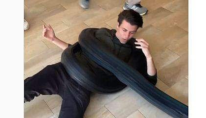 യുവാവിനെ മഴവില്‍ പാമ്പ് ചുറ്റിയ നിലയില്‍