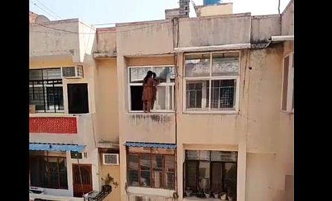 നാലാമത്തെ നിലയില്‍ സ്ത്രീയുടെ ജനല്‍ വൃത്തിയാക്കലിന്റെ ദൃശ്യം