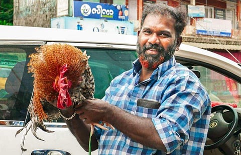 ലേലത്തിൽ പിടിച്ച പൂവൻ കോഴിയുമായി അജീഷ് മുതുകുന്നേൽ/ ഫെയ്സ്ബുക്ക്