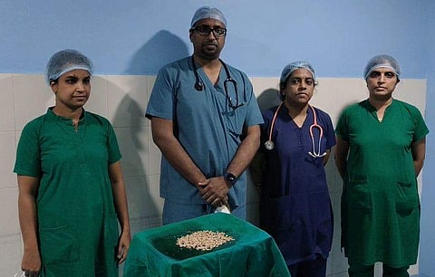 മൂത്രാശയത്തില്‍ നിന്നും പുറത്തെടുത്ത കല്ലുകളും ശസ്ത്രക്രിയ നടത്തിയ ഡോക്ടറും സംഘവും