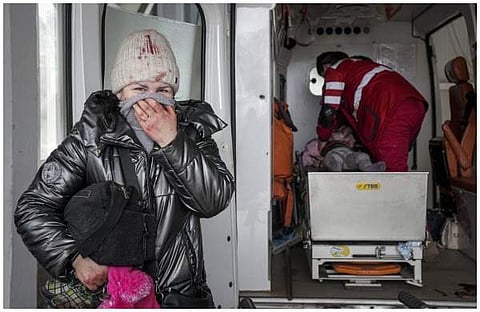 യുക്രൈനില്‍ റഷ്യന്‍ ഷെല്ലാക്രമണത്തില്‍ പരിക്കേറ്റയാളെ രക്ഷിക്കാന്‍ ശ്രമിക്കുന്ന ആരോഗ്യ പ്രവര്‍ത്തകര്‍, അടുത്തുനിന്ന് വിതുമ്പുന്ന യുവതി/എപി