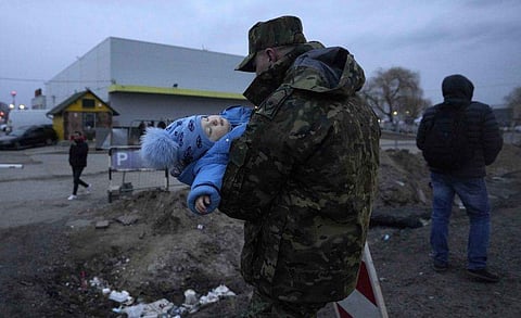 യുക്രൈന്‍ അഭയാര്‍ത്ഥിസംഘത്തിലെ കുട്ടിയെ കൈയിലെടുത്ത് സൈനികന്‍/ പിടിഐ ചിത്രം