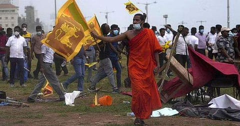 ശ്രീലങ്കയില്‍ പ്രസിഡന്റിന്റെ ഓഫീസിന് മുന്നിലെ  പ്രക്ഷോഭകാരികളെ അടിച്ചോടിക്കുന്ന സര്‍ക്കാര്‍ അനുകൂലികളുടെ കൂട്ടത്തില്‍ ബുദ്ധ സന്യാസി, എപി