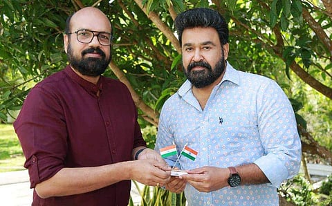 ദി ന്യൂ ഇന്ത്യൻ എക്സ്പ്രസിന്റെ കേരള റീജ്യണൽ ജനറൽ മാനേജർ വിഷ്ണു നായർ മോഹൻലാലിന് പതാക കൈമാറുന്നു