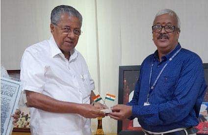 മുഖ്യമന്ത്രി പിണറായി വിജയന് എസ്‌കെ ശര്‍മ പതാക കൈമാറുന്നു