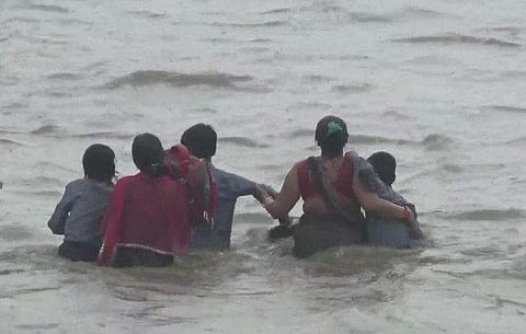 വെള്ളക്കെട്ടിലൂടെ നടന്നുനീങ്ങുന്ന വഴിയാത്രക്കാര്‍, എഎന്‍ഐ