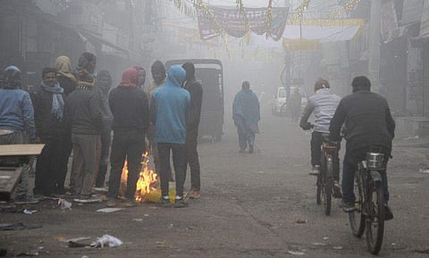 തണുപ്പില്‍ നിന്നും രക്ഷ തേടി ആളുകള്‍ തീ കായുന്നു/ പിടിഐ