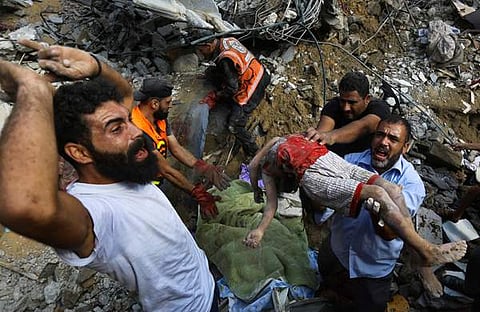 ഇസ്രയേൽ വ്യോമാക്രമണത്തിൽ കൊല്ലപ്പെട്ട കുട്ടിയുടെ മൃതദേഹവുമായി പലസ്തീൻകാരൻ/ പിടിഐ