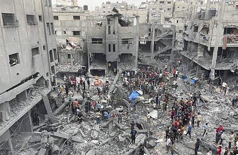 ഇസ്രയേൽ നടത്തിയ വ്യോമാക്രമണത്തിൽ തകർന്ന കെട്ടിടാവശിഷ്ടങ്ങൾക്കിടയിൽ ഉറ്റവരെ തിരയുന്നവർ. ഗാസ മുനമ്പിലെ ഷാതി അഭയാർഥി ക്യാമ്പിൽ നിന്നുള്ള ദൃശ്യം / പിടിഐ