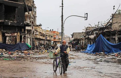 തകർന്ന ​ഗാസ ന​ഗരത്തിലൂടെ പോകുന്ന പലസ്തീൻകാരൻ/ പിടിഐ