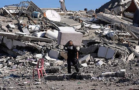 ഇസ്രയേൽ ആക്രമണത്തിൽ തകർന്ന വീടിനരികെ പലസ്തീൻകാരൻ/ പിടിഐ