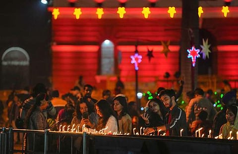 ക്രിസ്മസ് തലേന്ന് ന്യൂഡൽഹിയിലെ സേക്രഡ് ഹാർട്ട് കത്തീഡ്രൽ പള്ളിയിൽ ആളുകൾ മെഴുകുതിരികൾ കത്തിക്കുന്നു/ പിടിഐ