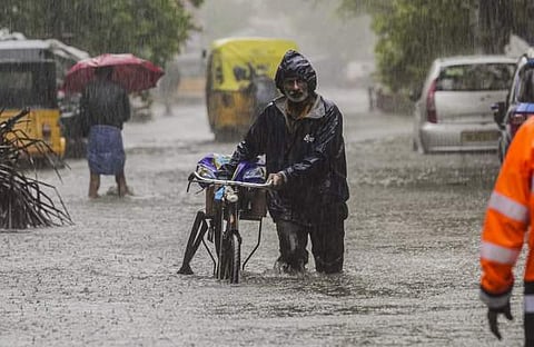 ചെന്നൈയിൽ വെള്ളക്കെട്ടിലൂടെ സൈക്കിൾ തള്ളിക്കൊണ്ടുപോകുന്ന യാത്രക്കാരൻ, പിടിഐ