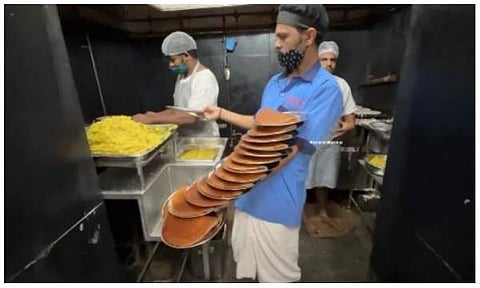 ഒരു കയ്യിൽ 16 പ്ലേറ്റ് ദോശയുമായി തൊഴിലാളി/ ചിത്രം സ്‌ക്രീൻഷോട്ട്