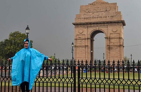 മഴയില്‍ ഇന്ത്യ ഗെയ്റ്റിനു മുന്നില്‍ ഫോട്ടോയ്ക്ക് പോസ് ചെയ്യുന്ന യുവതി/ ചിത്രം; പിടിഐ