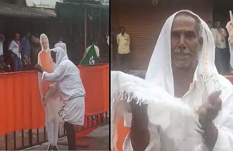 മോദിയുടെ കട്ടൗട്ടിൽ നിന്നും മഴവെള്ളം തുടച്ചു നീക്കുന്ന വൃദ്ധൻ/ ചിത്രം വീഡിയോ സ്ക്രീൻഷോട്ട്