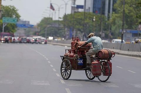 പൊരിവെയിലില്‍ എല്‍പിജി സിലിണ്ടറുമായി പോകുന്ന തൊഴിലാളി/ പിടിഐ