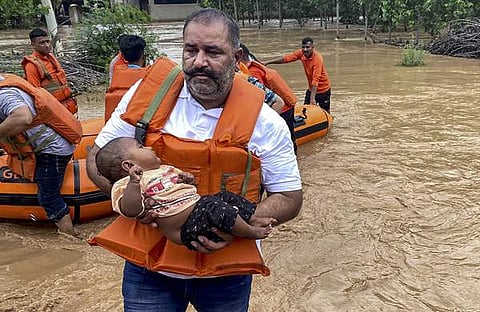 വെള്ളപ്പൊക്ക ബാധിത പ്രദേശത്ത് നിന്ന് കുഞ്ഞിനെ രക്ഷിക്കുന്ന ദൃശ്യം, പിടിഐ