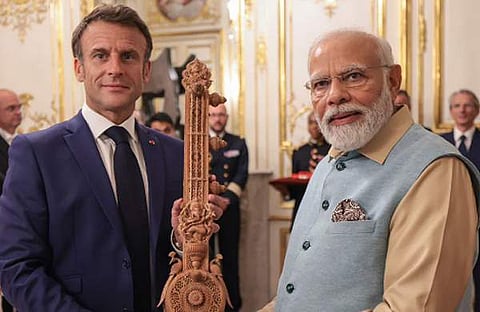 ഫ്രഞ്ച് പ്രസിഡന്റ് ഇമ്മാനുവല്‍ മാക്രോണിന് മോദി സിതാര്‍ കൈമാറുന്നു