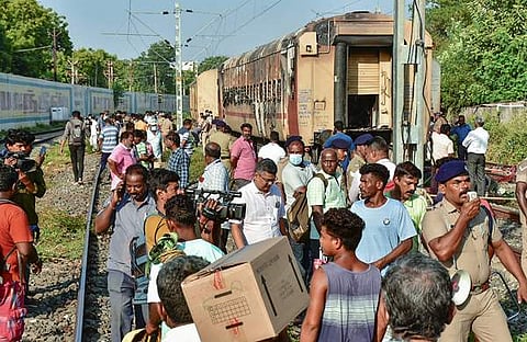 മധുരയില്‍ തീപിടിത്തമുണ്ടായ ട്രെയിന്‍ കോച്ചിനു സമീപം യാത്രക്കാരും സുരക്ഷാ ഉദ്യോഗസ്ഥരും/പിടിഐ