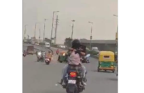 ഇന്ധന ടാങ്കില്‍ ഹെല്‍മറ്റ് ധരിക്കാതെ യുവതി; ബൈക്കില്‍ പരസ്പരം കെട്ടിപ്പിടിച്ച് കമിതാക്കളുടെ 'പ്രണയലീല' - വീഡിയോ 